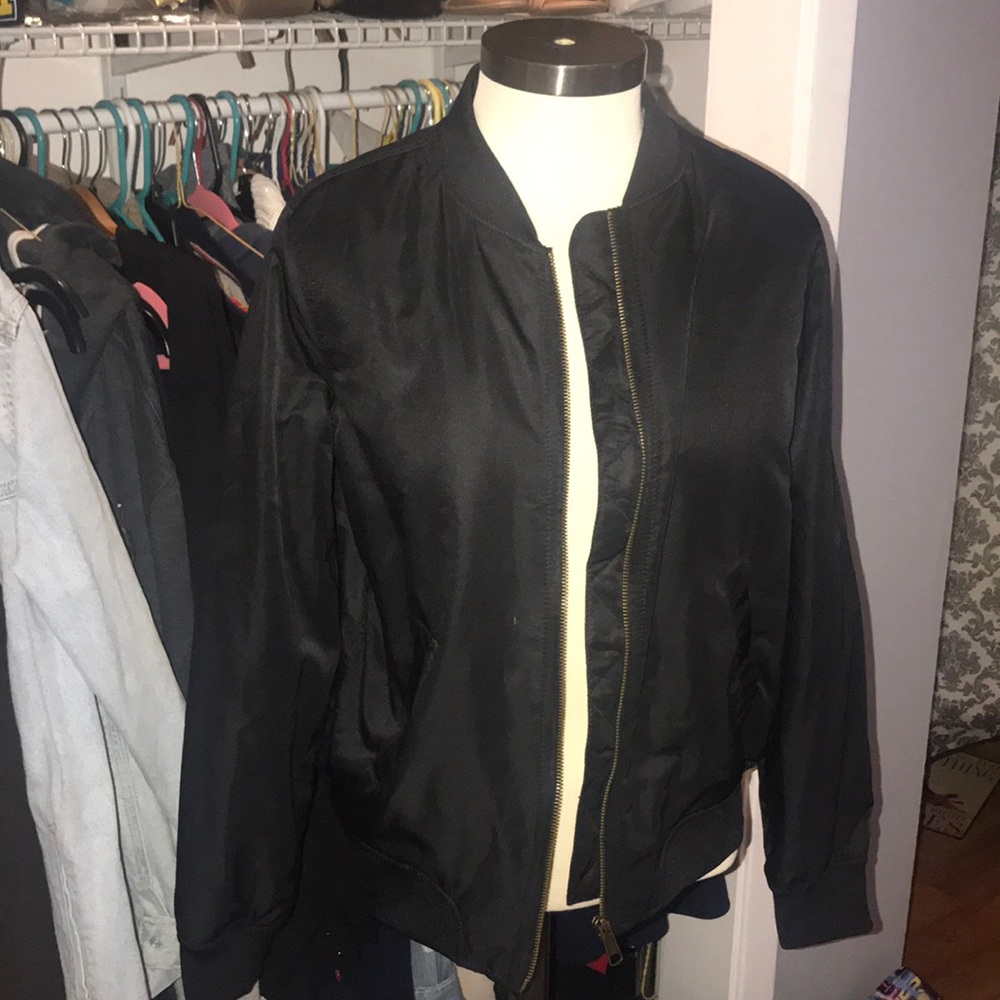 Black bomber jacket with zipper in the middle.